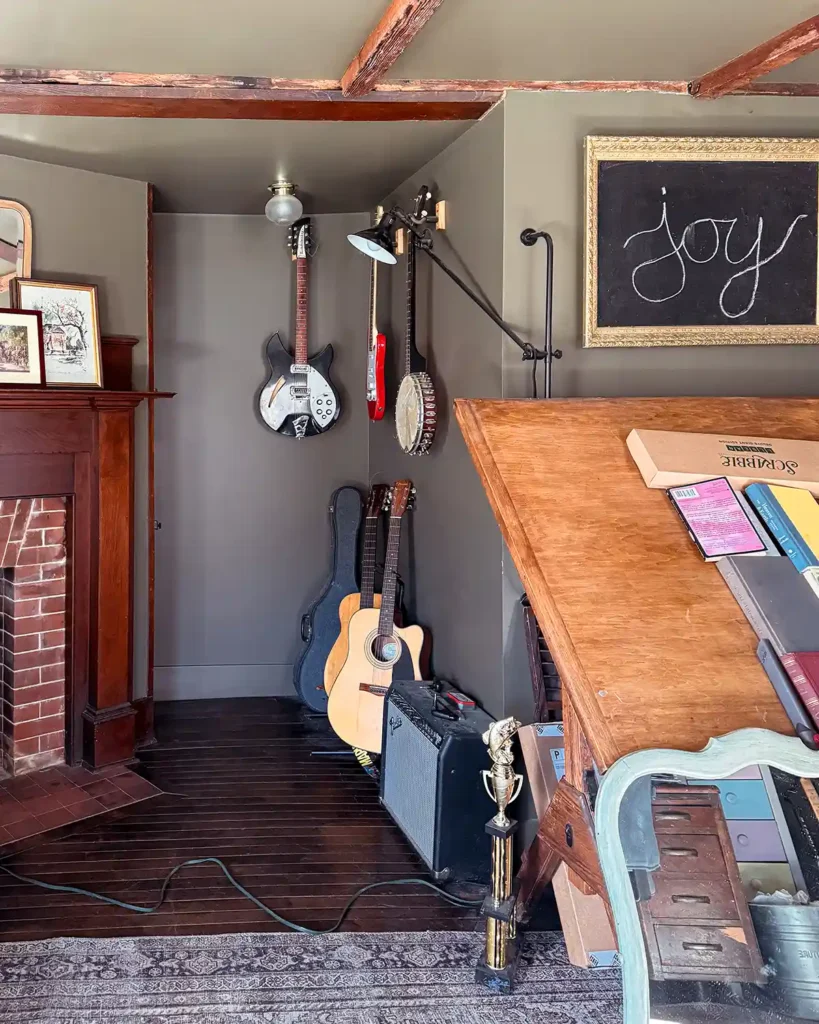 The music zone in our keeping room, a home office space, with guitars, an amp, and a banjo hanging on the wall