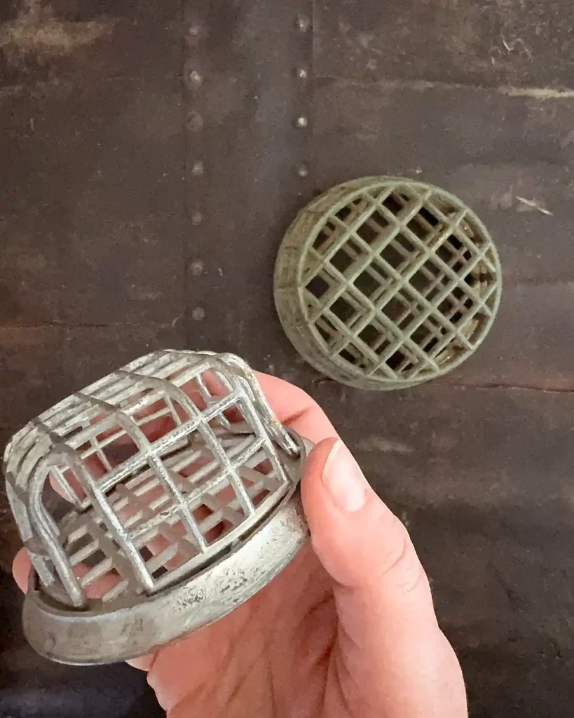 A pair of vintage metal cage flower frogs, one a silver color and the other a green color