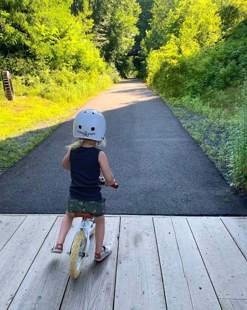 A springtime family bike ride along a rail trail with a child riding a strike bike