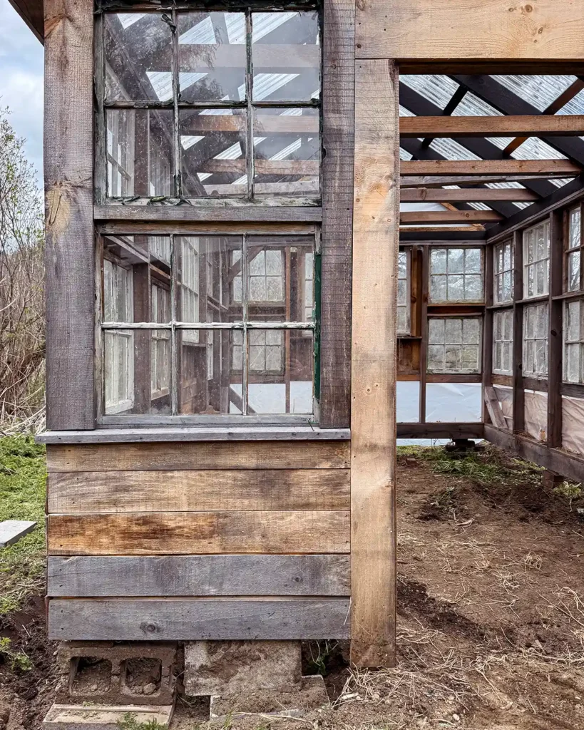 A leveled greenhouse with extra supports and footers around the door opening to keep it in place