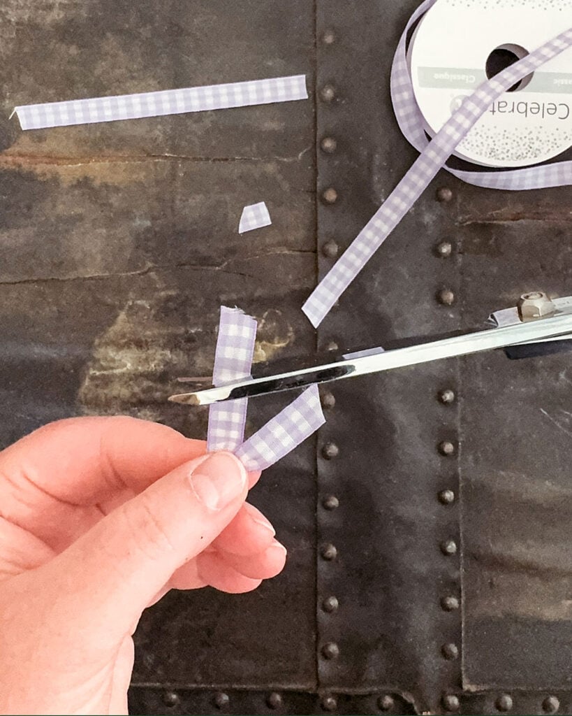 Trimming the ends of ribbon at an angle using a pair of fabric scissors