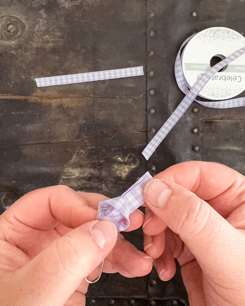 Tying ribbon around the end of a paperclip using a cow hitch knot