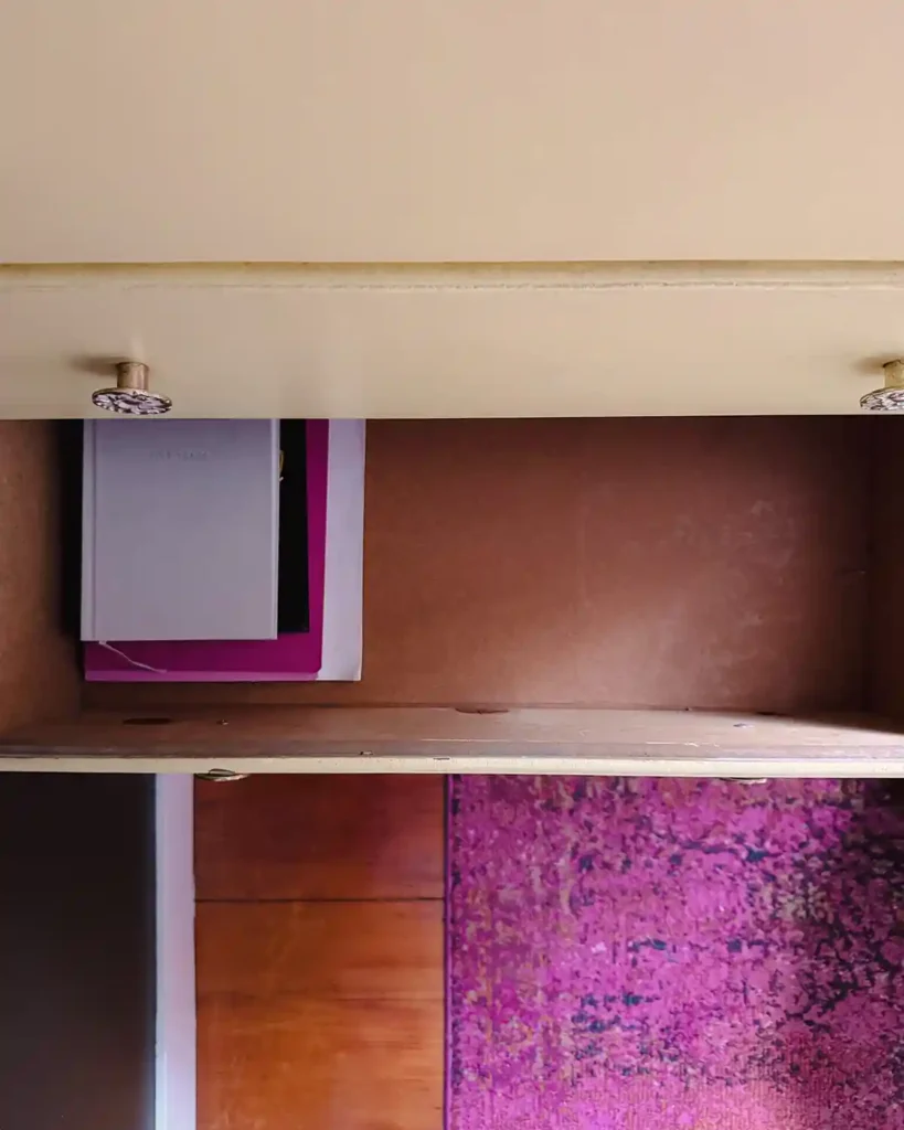 An opened drawer in a yellow dresser that's in the process of getting organized with notebooks and planners