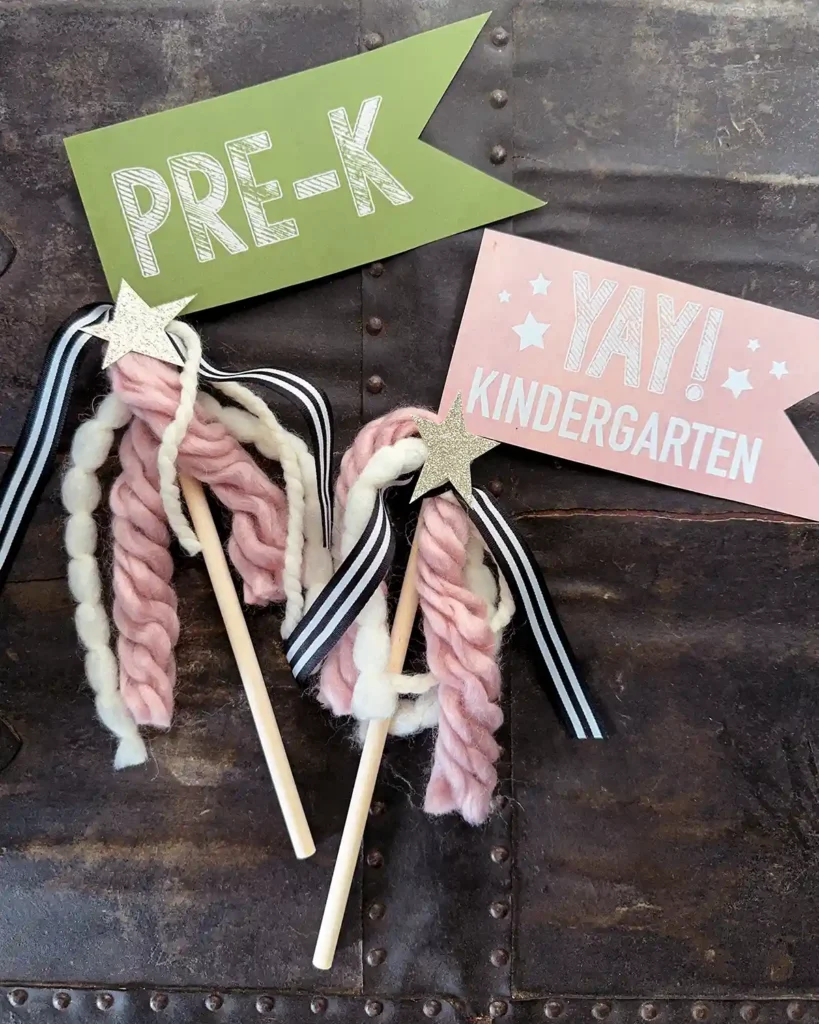 First day of preschool and kindergarten flags made from green and pink paper flags, wooden dowels, yarn embellishments, and glittery stars