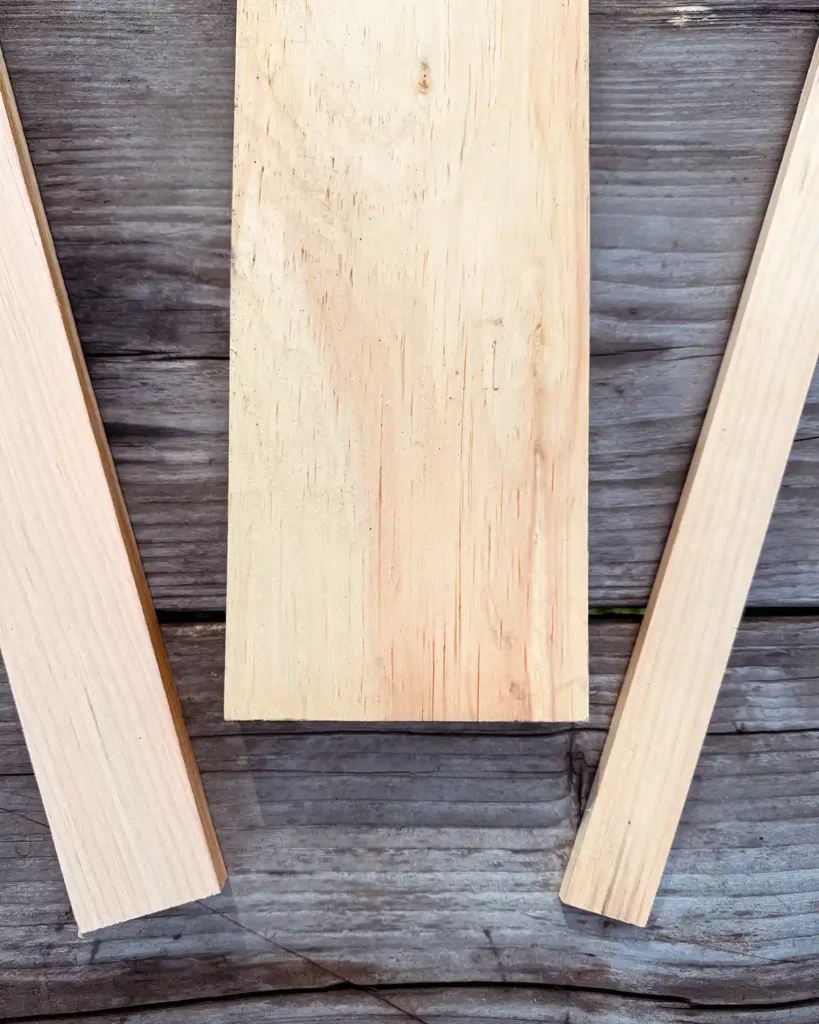 The three wooden components into build the DIY ledge book shelves in unfinished pine sitting on an outdoor table